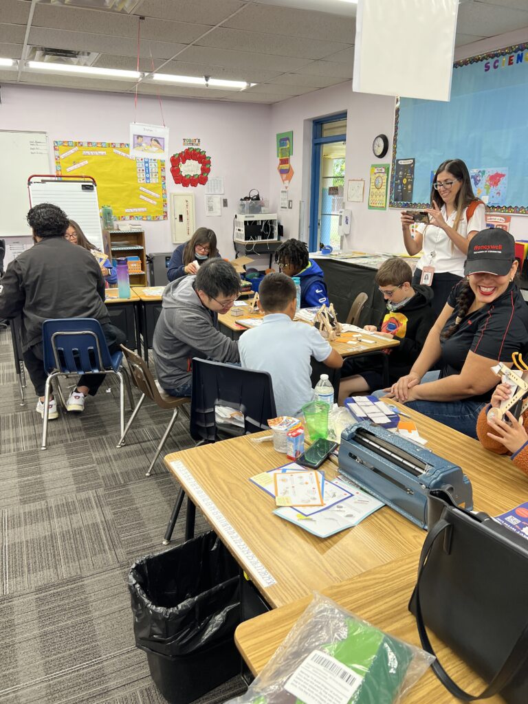 students working on building their robot and volunteers helping